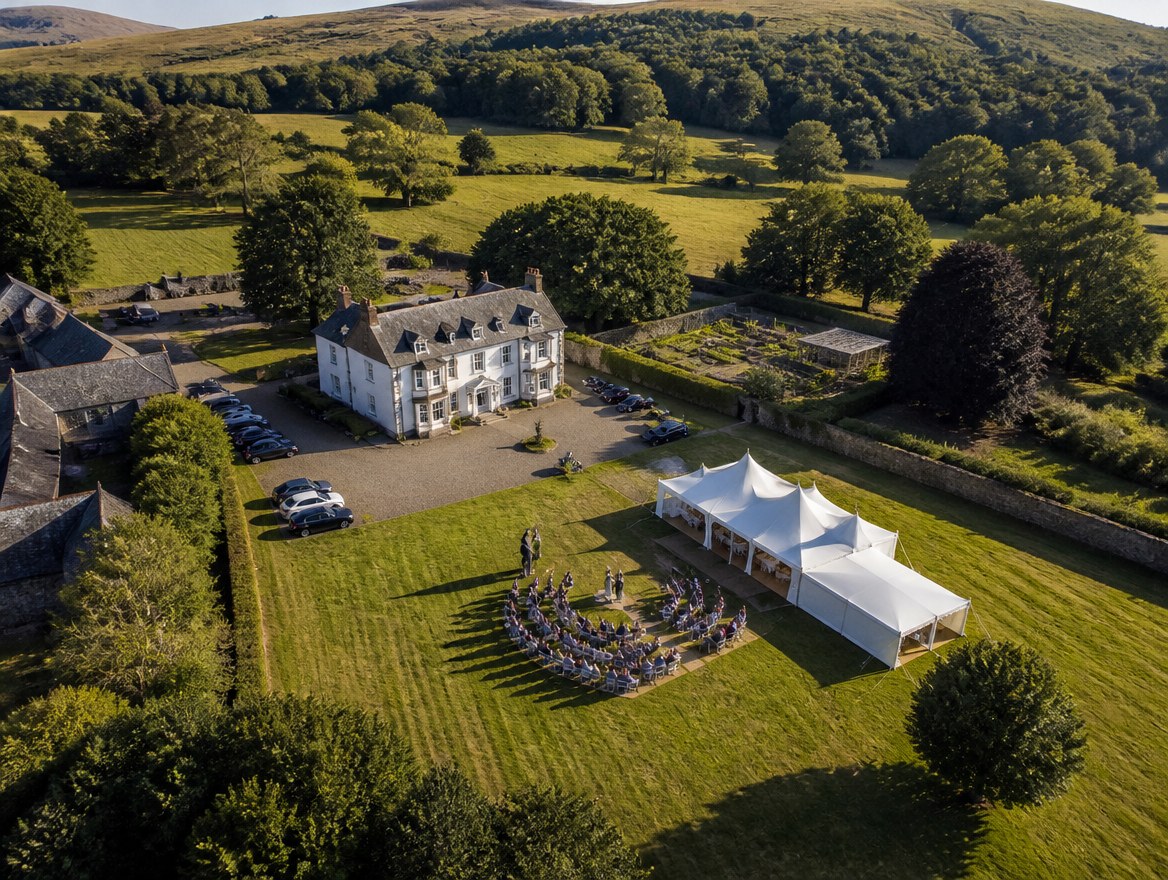 A country house wedding, marquee and ceremony, seen from the air